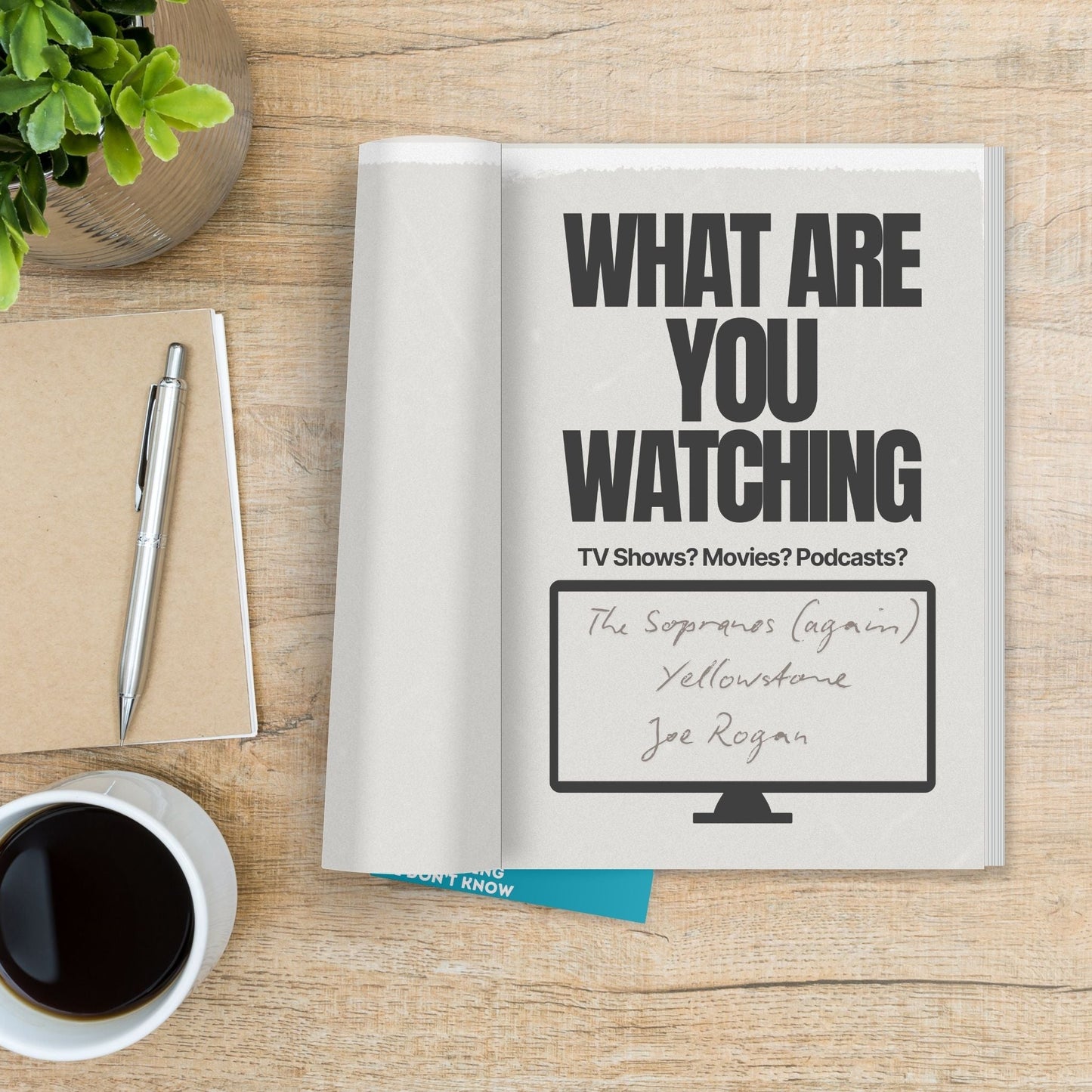 Hey, Dad! Tell Me Something I Don't Know journal with prompts about TV shows, movies, and podcasts on a wooden table.